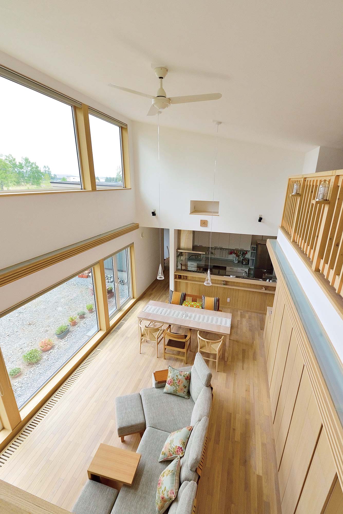 ロフトからLDKを見る。大きな壁収納と開口の上には、タモ材で造作した間接照明が設置され、夜には落ち着いたくつろぎ空間になる