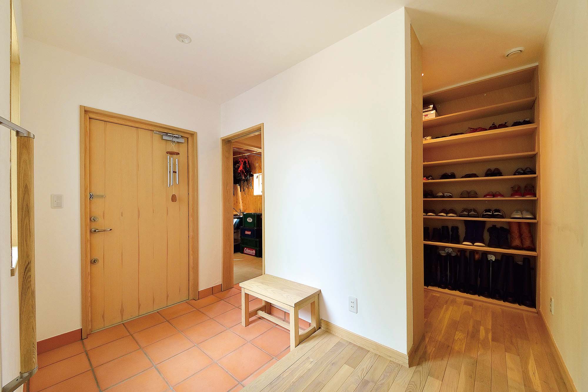 テラコッタタイルが敷かれた玄関にはシューズクローゼットのほか、土間づくりの収納スペースを設置。山歩きの道具、アウトドア用品の手入れなどもできるよう、小さなシンクも取り付けられている