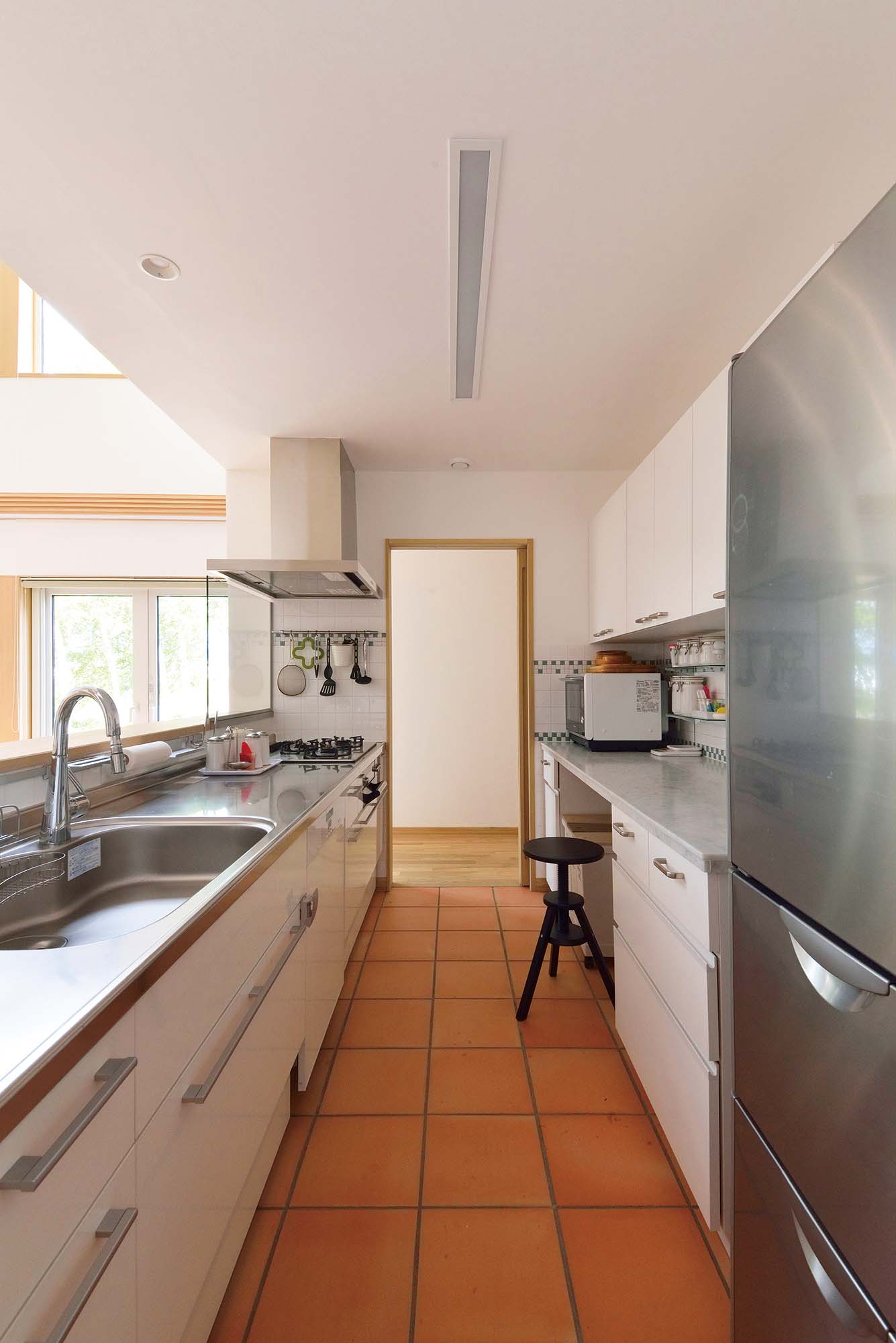 システムキッチンにミーレの食洗機を組み込んだ対面キッチン。背面には大理石カウンターのある造作収納もしつらえた