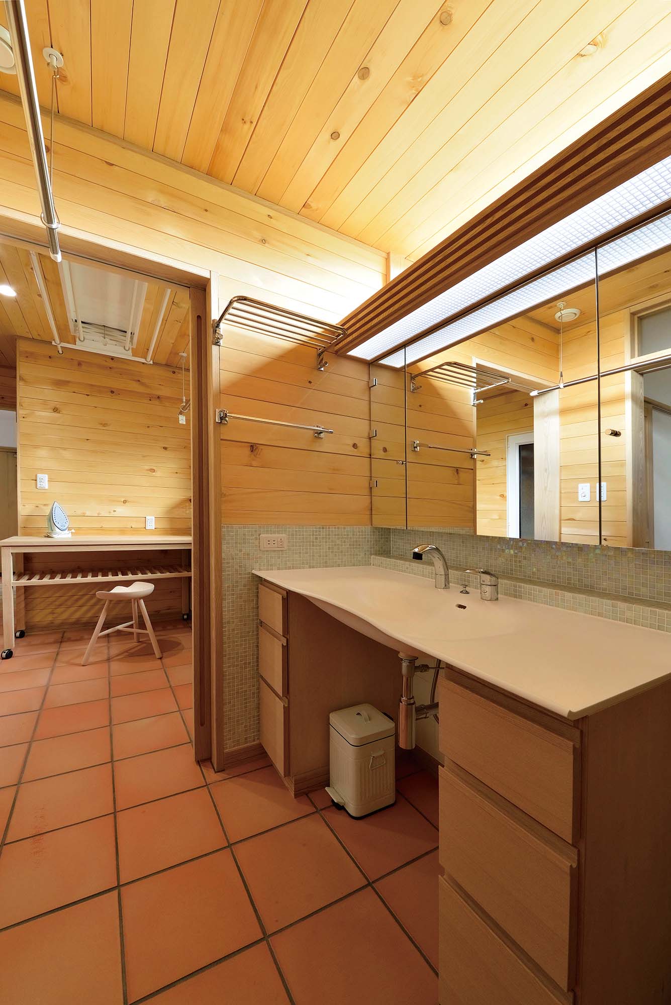 タモを用いた造作洗面は、掃除がしやすい人工大理石一体型ボウルを採用。水まわりの天井には抗菌作用があり、湿気にも強いヒバ材を採用。テラコッタの床には床暖房を備え、冬も足元から暖かい