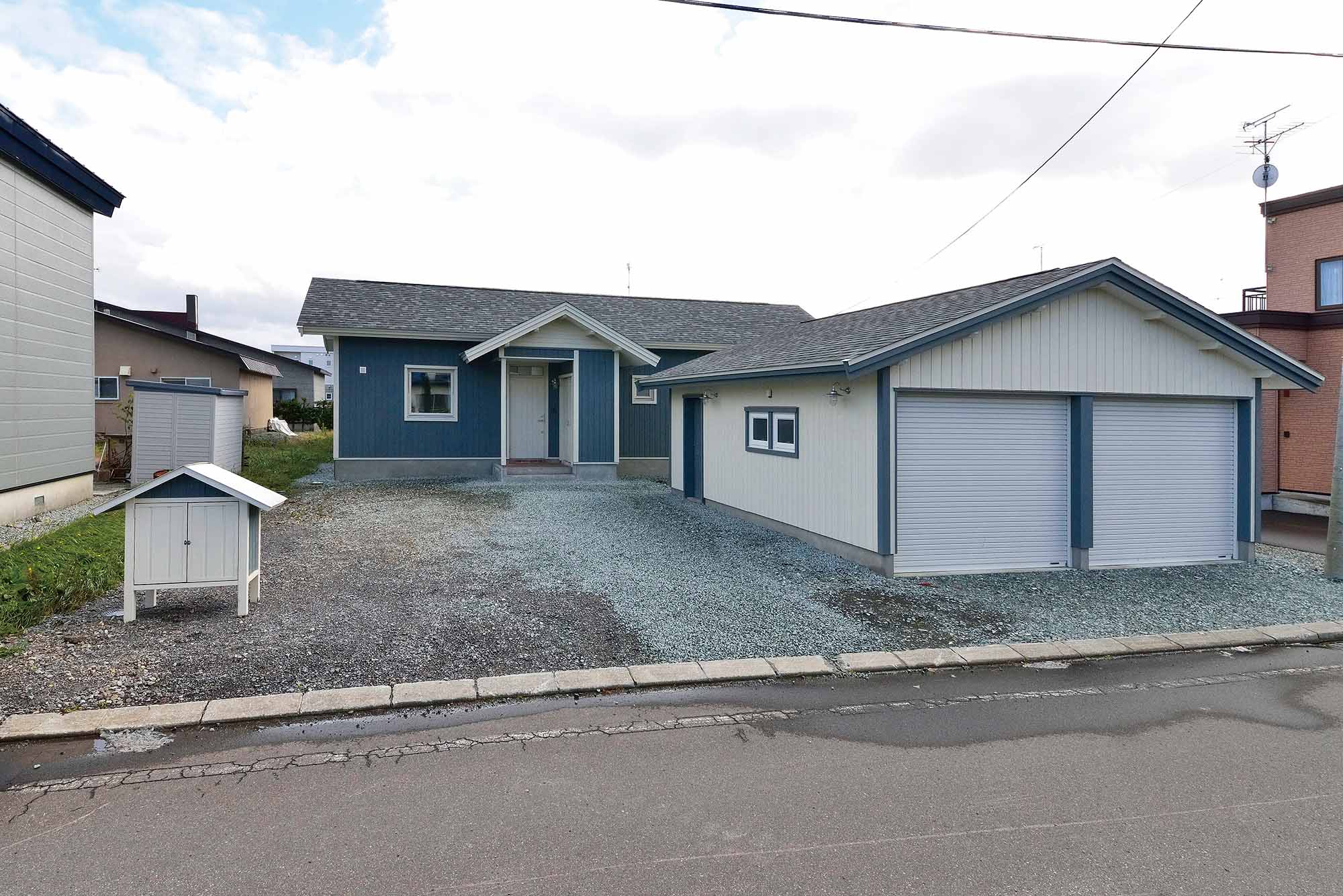 母屋の外観デザインと合わせて、別棟の車庫も設置。玄関は奥まった位置にレイアウトし、建物が小さく見えるように工夫した