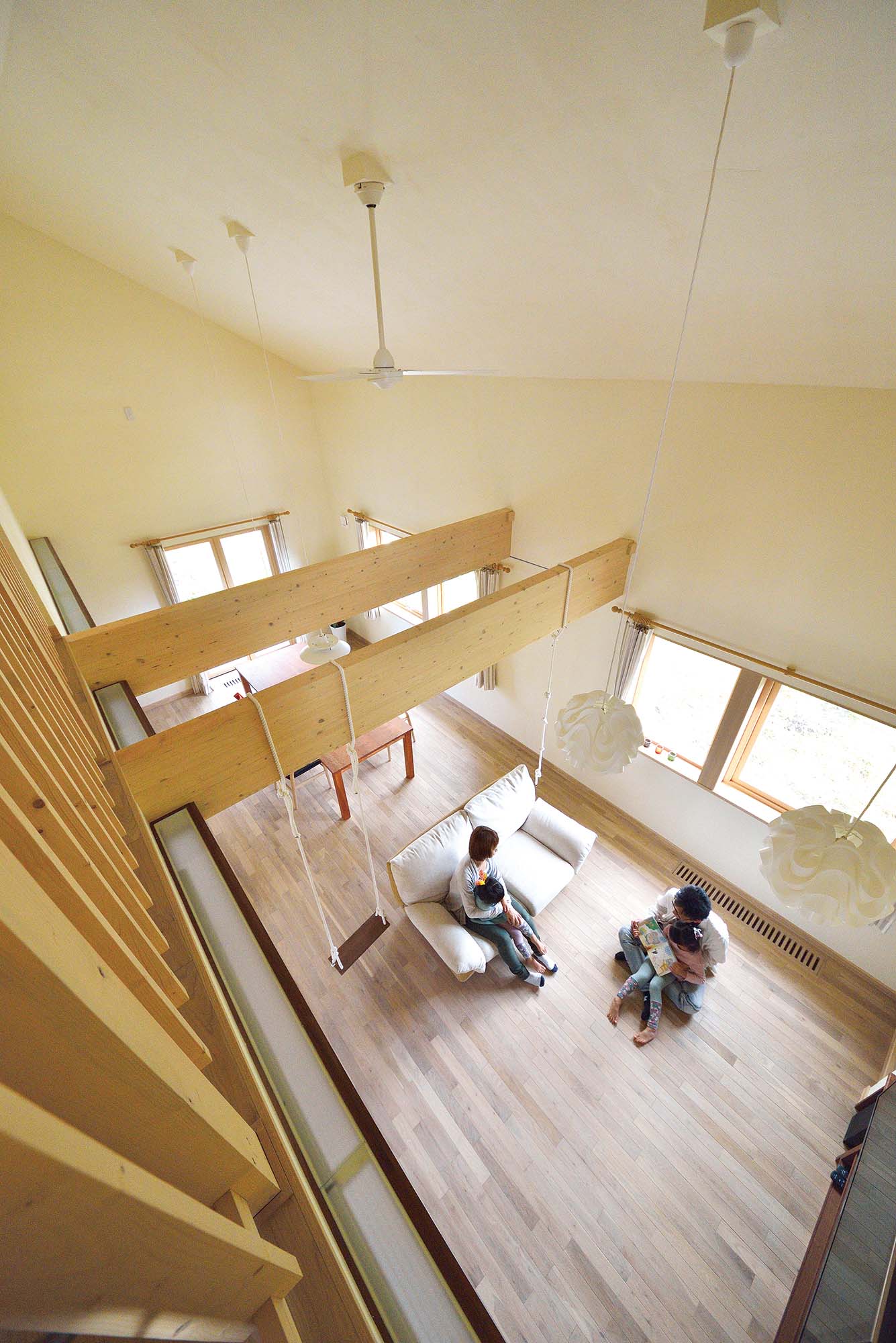 開放感たっぷりの屋根なりの天井にマツ材の梁、ロフトの手すりのラインがアクセントをつけるリビング・ダイニングは、目にも心地よい家族のくつろぎ空間