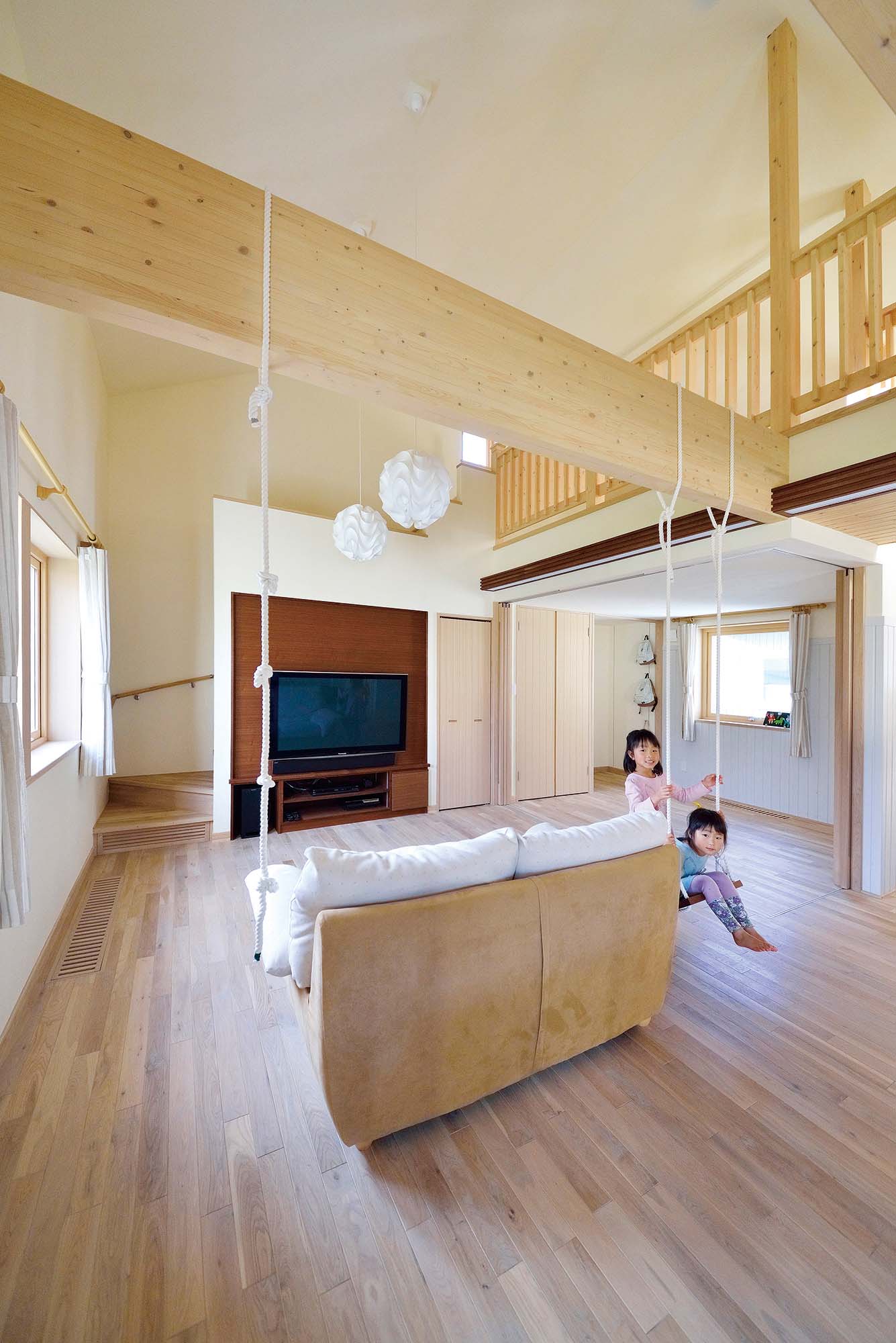 梁には、活発な子どもたちが楽しく遊べるようブランコやロープが取り付けられている。リビングに隣接して、予備室にもなる子どもスペースを設けた。奥さんは、キッチンで家事をしながらその様子を見守ることができる
