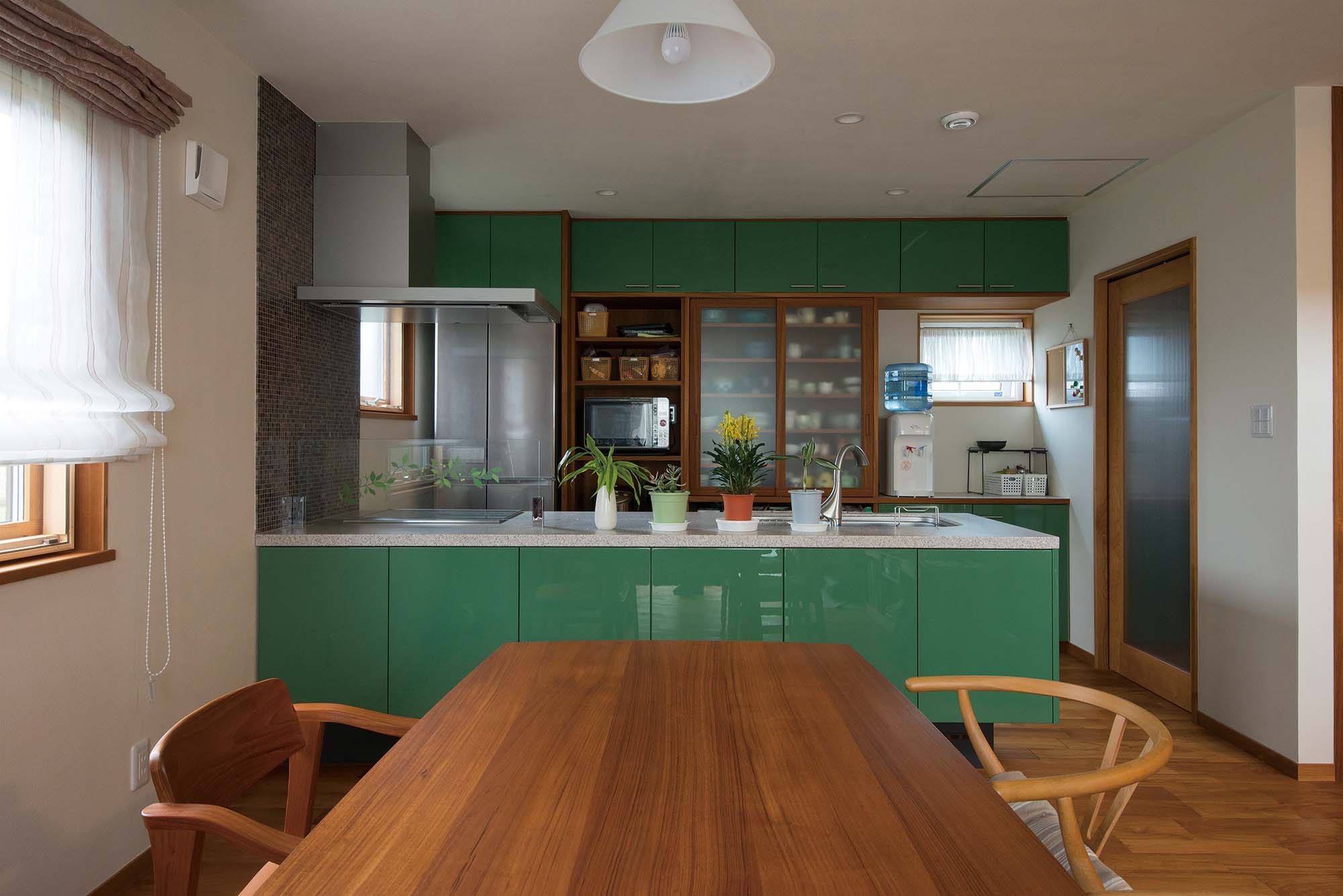 グリーンのキッチンは奥さんの要望。使い勝手を考えて棚の配置や大きさを家具職人のご主人にリクエストしてつくったオリジナル