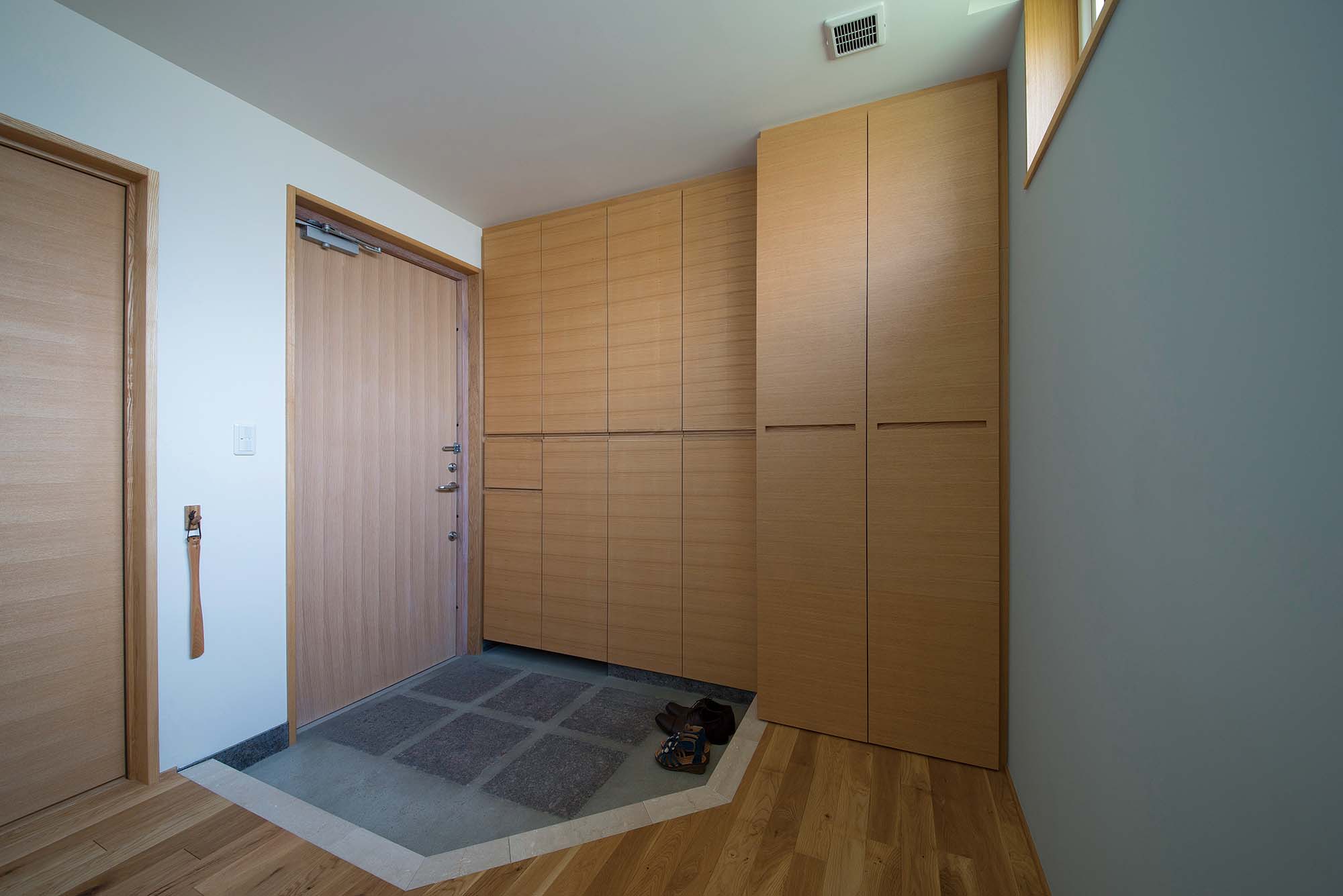 大容量の玄関収納を備えた玄関ホール。左手は親との同居も考慮した洋室で、トイレや浴室へもすんなり行ける動線になっている