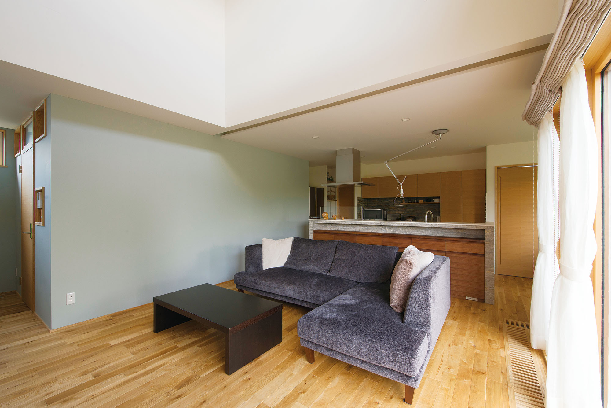 ブルーの壁の向こうは家族全員の衣類を収納する大容量のウォークインクローゼットになっており、洗濯機のあるユーティリティを経てバスルームへとつながっている