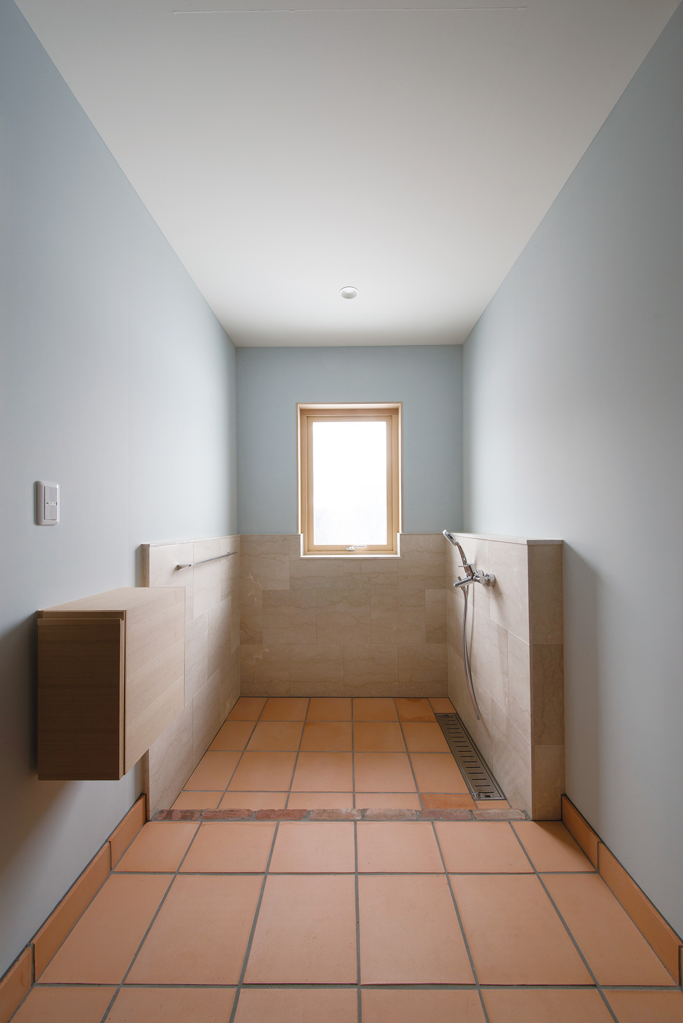 テラコッタタイルを採用した玄関には、愛犬との暮らしに備えて、足洗い場も設置。造作収納やシャワー金具のデザインにもこだわった