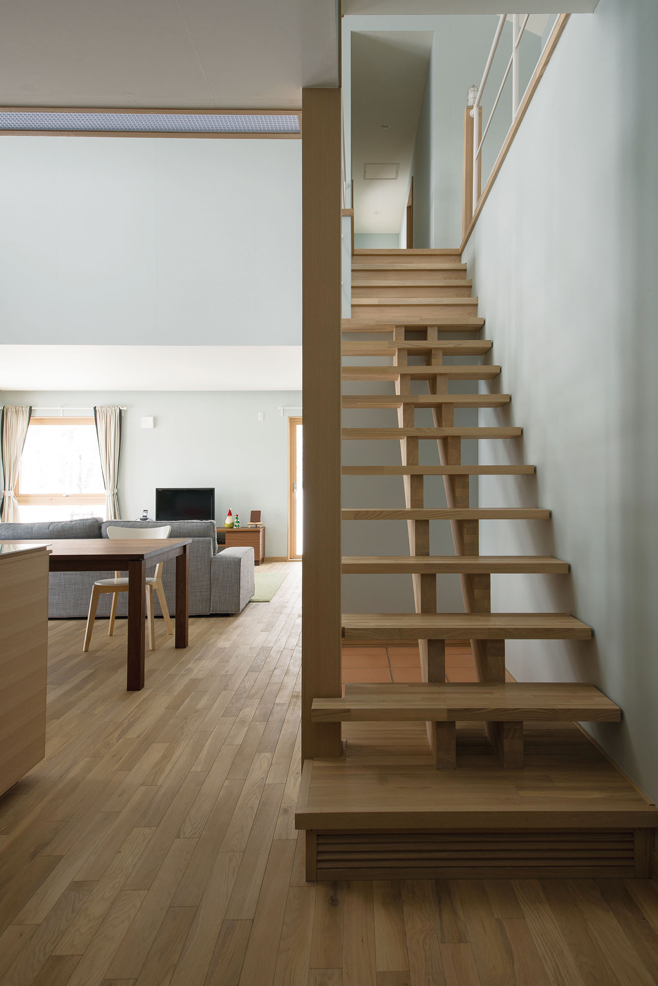 スケルトンの軽快なリビング階段の下は、テラコッタタイルを張り、愛犬のゲージが収められるようにしてある