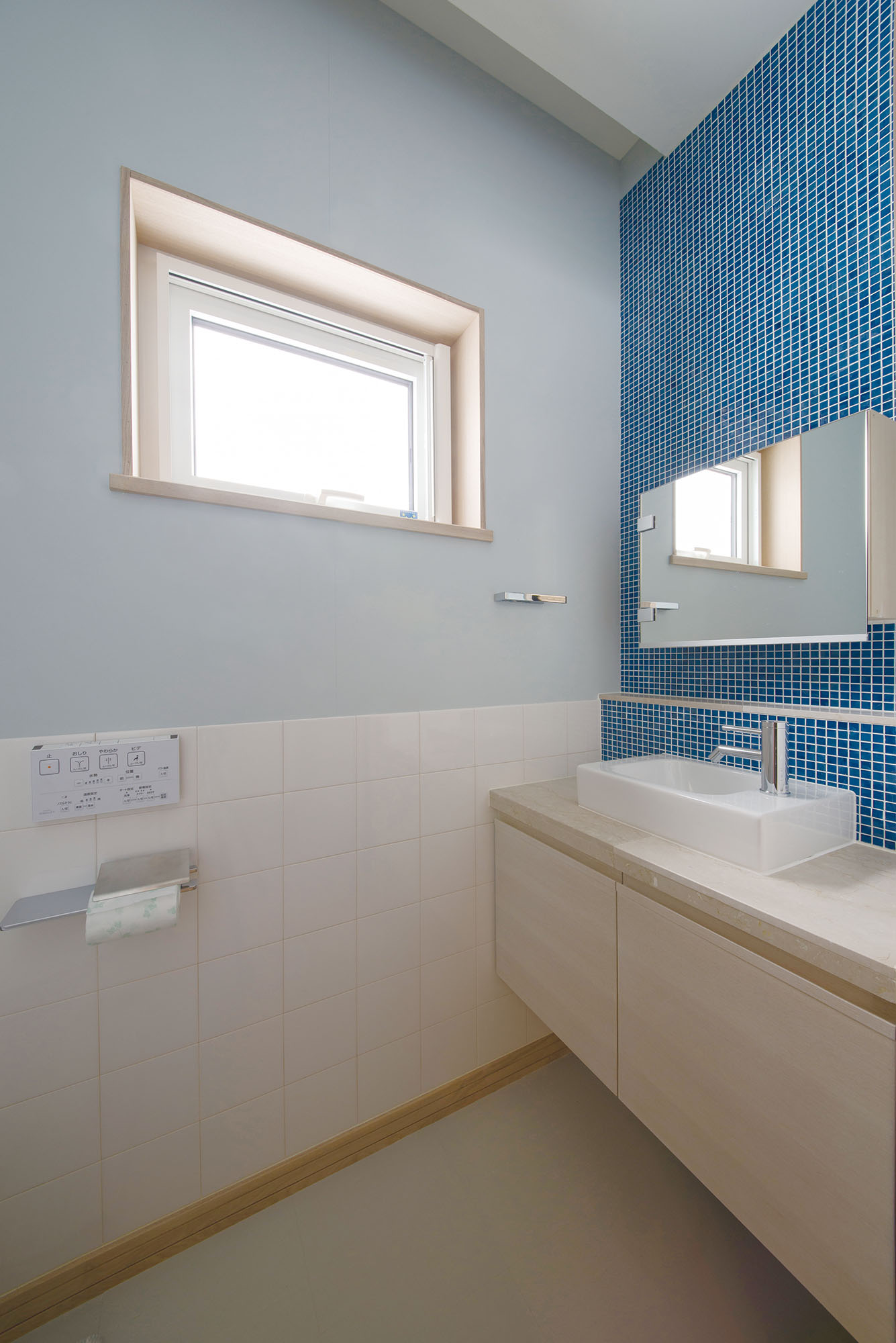 モザイクタイル張りの手洗いを設けたトイレも、Fさん宅のテーマカラーで整えている。造作の端正さも、アクト建築工房ならでは