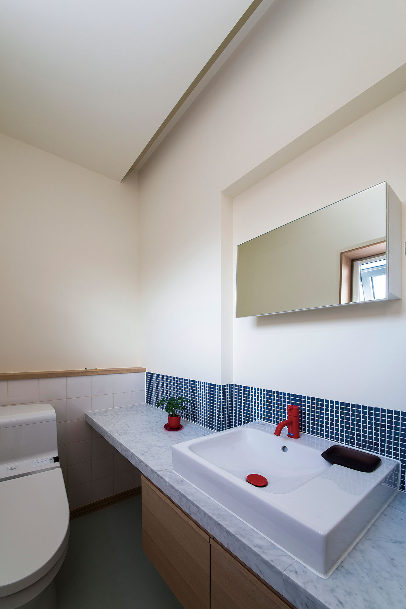 ゆとりある空間を確保したトイレにはタイルと大理石カウンターも