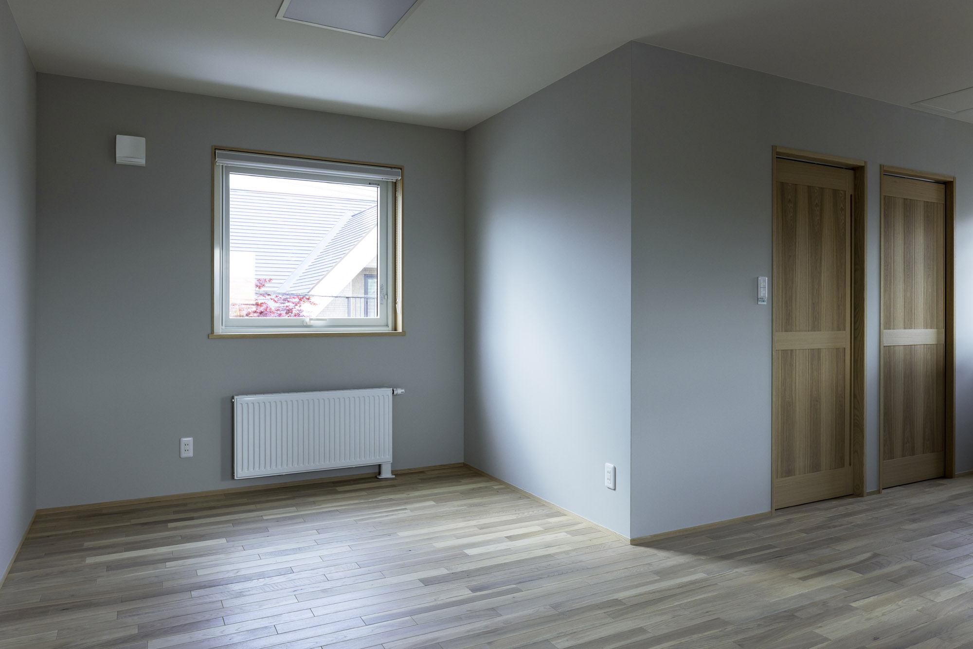 2階ホールは将来的に間仕切って子ども部屋にもできる。建具はタモ枠材に合わせて同材で造作しており、美しく統一感がある